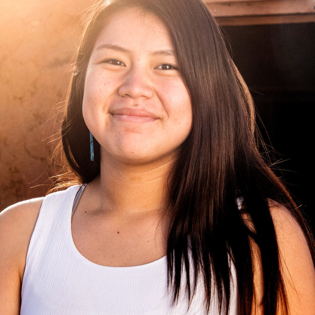 Pretty and Cheerful Native American Indian Teenage girl in an outdoor closeup environmental portrait